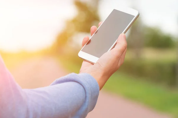 Vrouw met smartphone buiten — Stockfoto