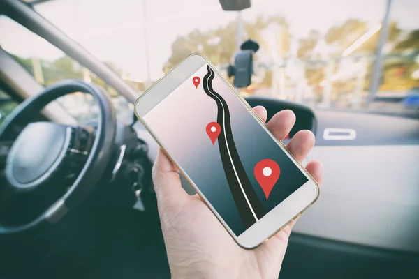 Hand met smartphone in een auto — Stockfoto