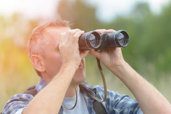 Man looking through binocular — Stock Photo, Image