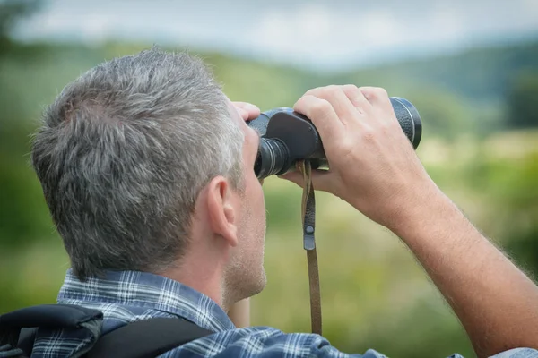 Homem olhando através binocular — Fotografia de Stock