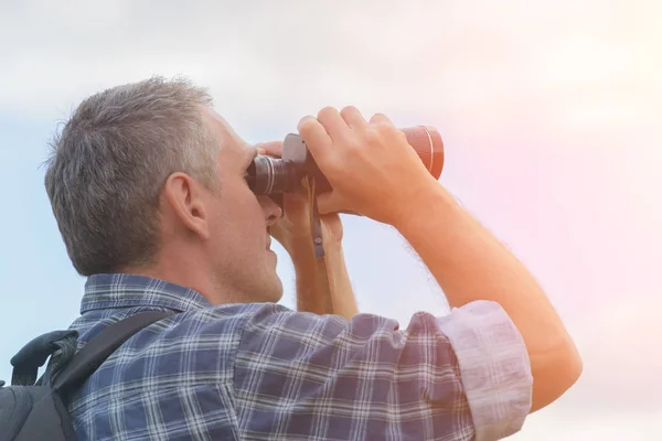 Hombre mirando a través de binocular — Foto de Stock