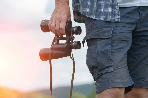 Homem na trilha segurando binóculos — Fotografia de Stock