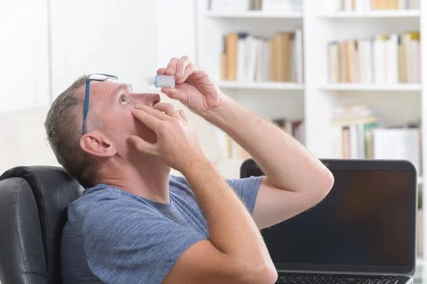 Hombre aplicando gotas para los ojos — Foto de Stock