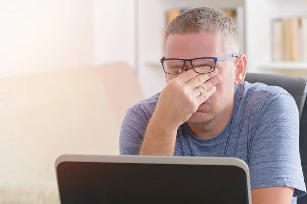 Tired freelancer man rubbing his eye — Stock Photo, Image