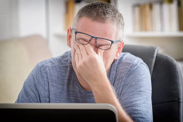 Hombre freelancer cansado frotándose el ojo —  Fotos de Stock