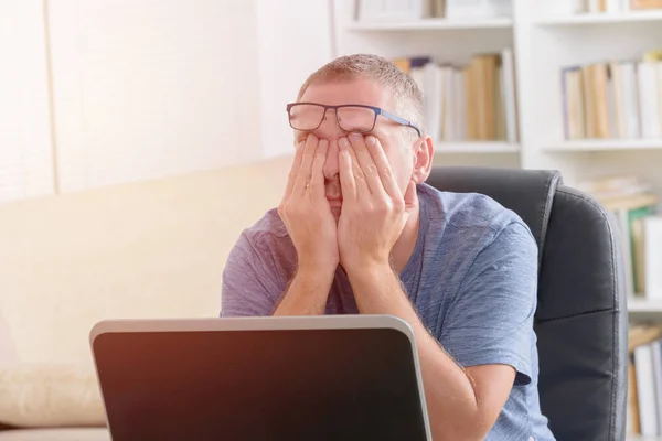 Hombre freelancer cansado frotándose el ojo —  Fotos de Stock