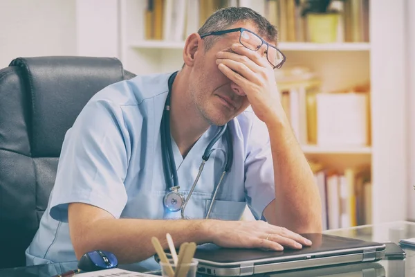 Überlasteter Arzt in seinem Büro — Stockfoto
