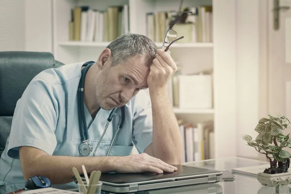 Überlasteter Arzt in seinem Büro — Stockfoto