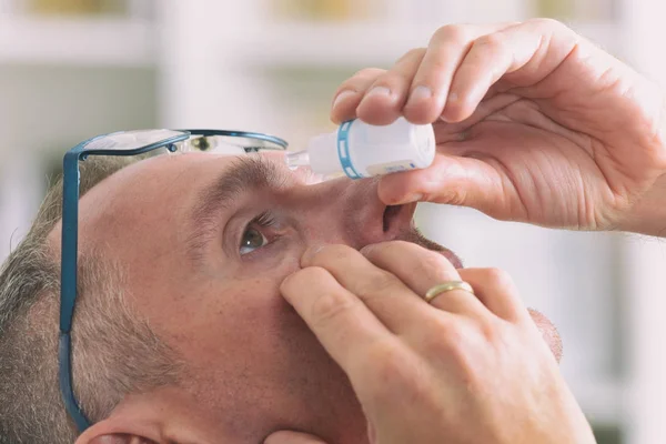 Man applying eye drops — Stock Photo, Image