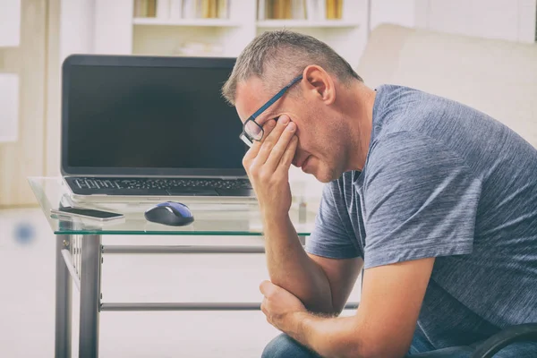 Tired freelancer man rubbing his eyes — Stock Photo, Image
