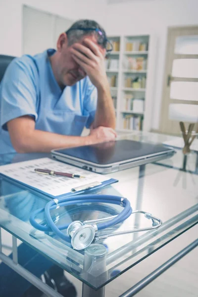 Überlasteter Arzt in seinem Büro — Stockfoto