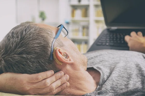 Homem deficiente auditivo usando laptop — Fotografia de Stock