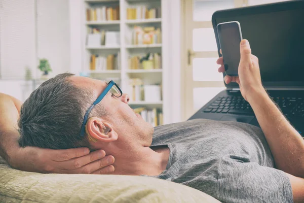 A Hallássérülés ember laptop és mozgatható telefon — Stock Fotó