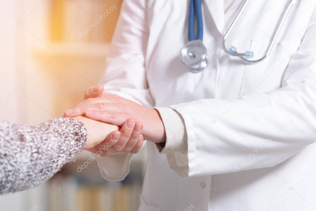 Doctor holding patient's hand