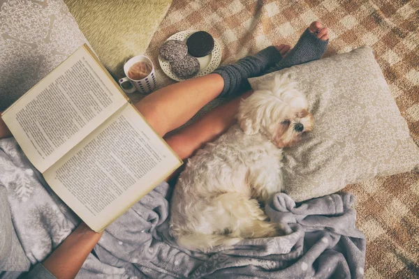 Donna sdraiata sul letto con cane — Foto Stock