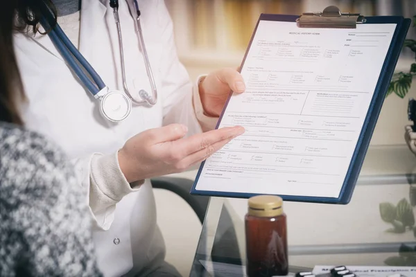 Médico apresentando formulário de história médica — Fotografia de Stock