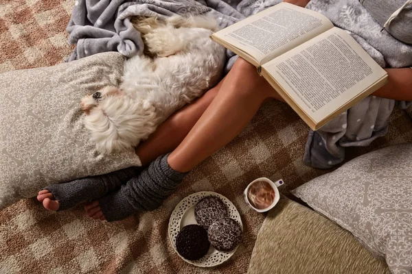 Woman lying on bed with dog — Stock Photo, Image