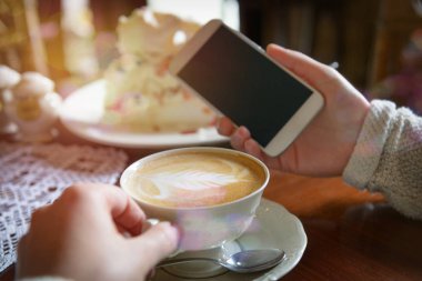 Kafede akıllı telefon kullanan kadın