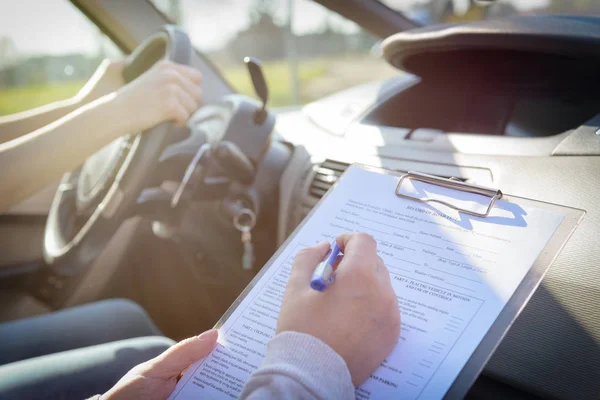 Examinador rellenando el formulario de prueba de la licencia de conducir —  Fotos de Stock