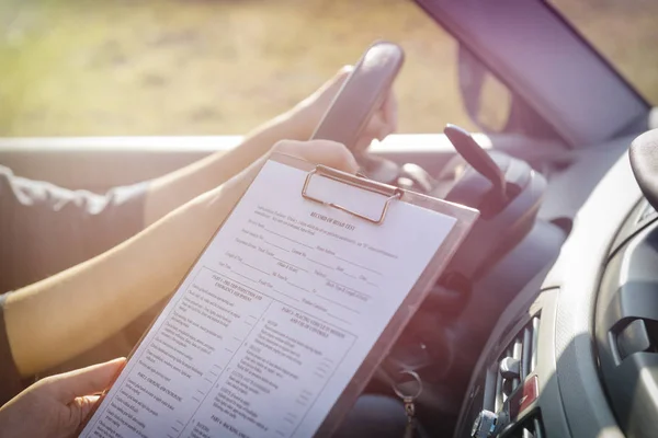 Prüfer füllt Formular für Führerscheinprüfung aus — Stockfoto