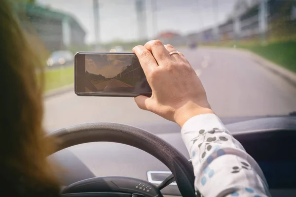 कार चालवताना स्मार्ट फोन कॅमेरा वापरून स्त्री — स्टॉक फोटो, इमेज
