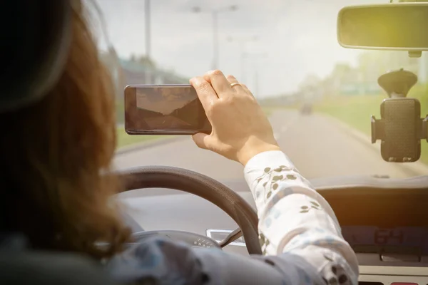 Vrouw met behulp van slimme telefooncamera tijdens het rijden de auto — Stockfoto