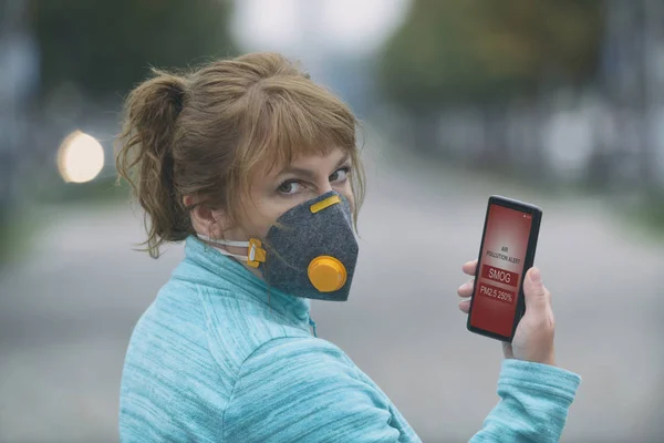 Žena na sobě skutečný anti-smog obličejová maska a kontrolu aktuální ai — Stock fotografie