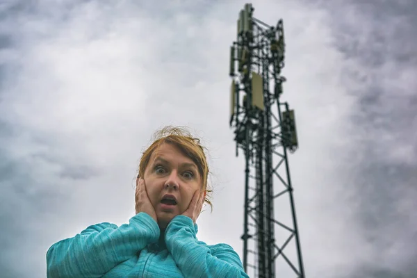 Mujer sostiene su cabeza cerca de la 5G BTS —  Fotos de Stock