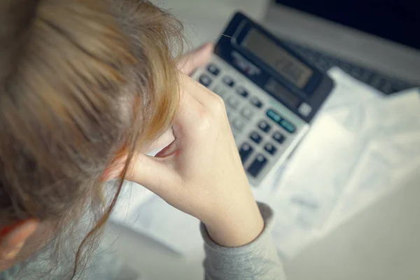 Žena používá kalkulačku pro sčítání výdajů doma — Stock fotografie