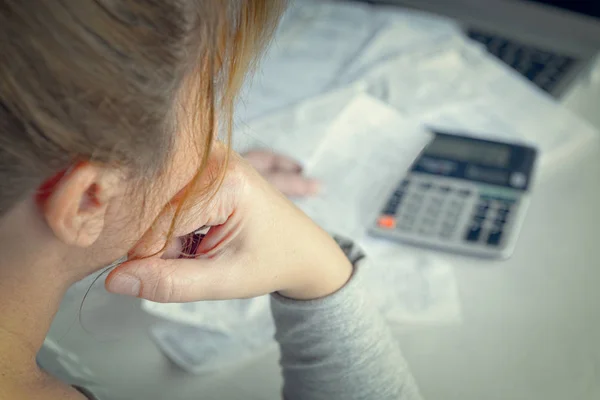 Женщина использует калькулятор для подведения итогов расходов на дому — стоковое фото