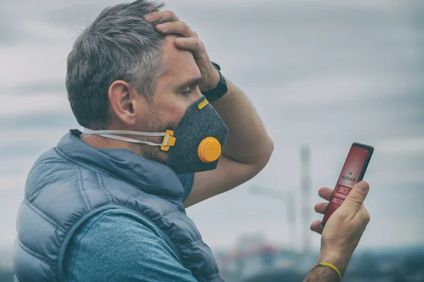 Homem vestindo uma verdadeira máscara facial anti-smog e verificando o ar atual — Fotografia de Stock