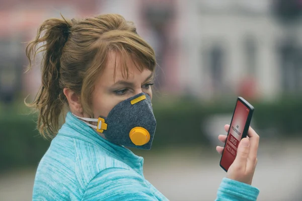 Femme portant un vrai masque anti-smog et vérifiant le courant ai — Photo