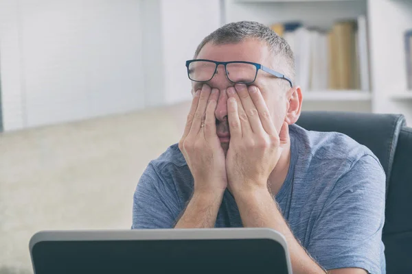 Tired freelancer man rubbing his eye — Stock Photo, Image