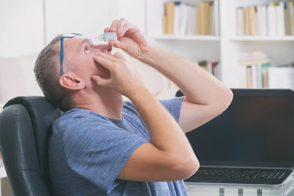 Mann verabreicht Augentropfen — Stockfoto