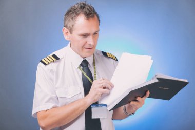 Seyir defterini dolduran ve belgeleri kontrol eden pilot