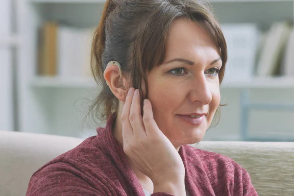 Deaf woman wearing hearing aid — Stock Photo, Image