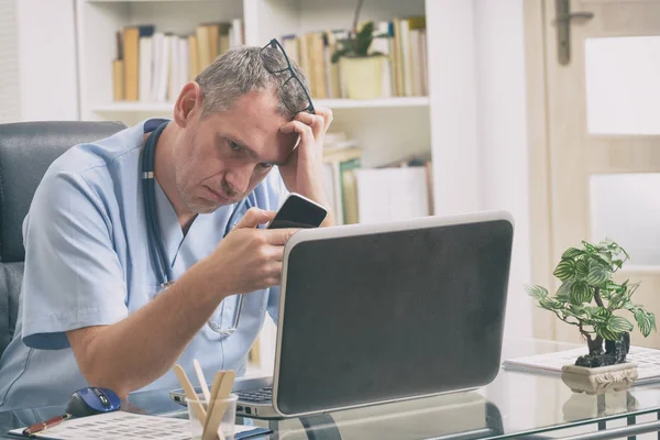 Överarbetad läkare på sitt kontor — Stockfoto