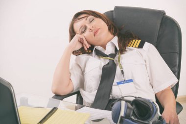 Ofiste uyuyan kadın havayolu pilotu