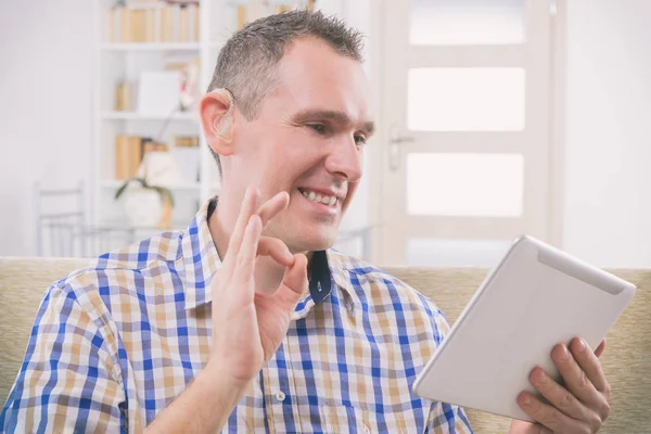 Deaf man using sign language on the tablet