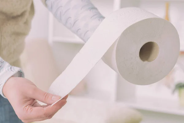 Mão segurando papel higiênico em casa — Fotografia de Stock
