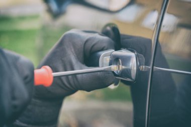 Hırsız arabanın kilidini tornavidayla açıyor.