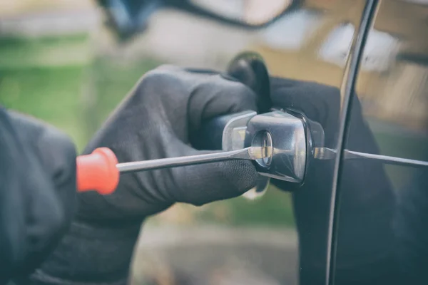 Dief opent het autoslot met een schroevendraaier — Stockfoto