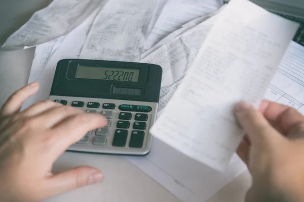 Femme utilise une calculatrice pour résumer les dépenses — Photo