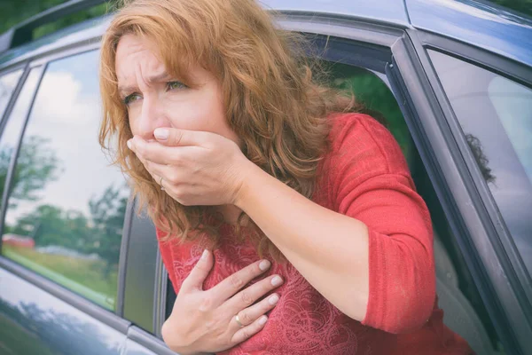 Woman suffering from motion sickness in a car