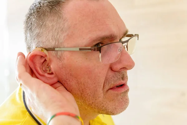 Człowiek Noszący Głuchą Pomoc Uchu Próbuje Coś Usłyszeć — Zdjęcie stockowe