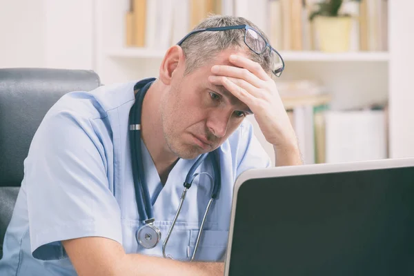 Überlasteter Arzt Sitzt Seinem Büro — Stockfoto