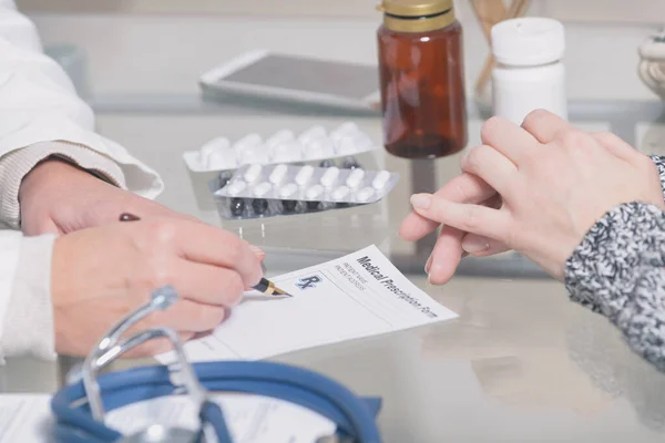 Kobieta Lekarz Wypisuje Receptę Dla Pacjenta Stole Roboczym — Zdjęcie stockowe