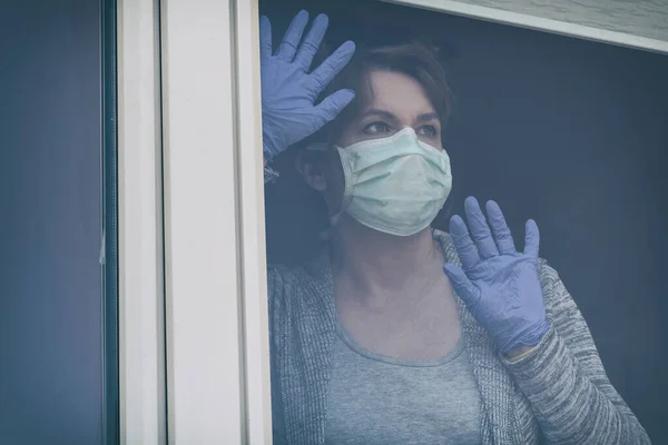 Женщина Защитной Маске Выглядывает Окно Своего Дома Эпидемии Коронного Вируса — стоковое фото