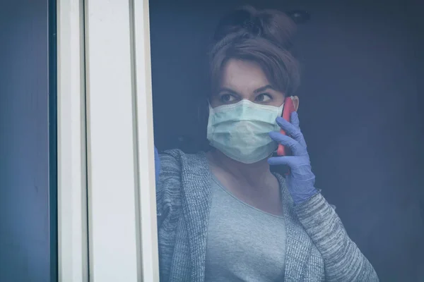Vrouw Met Een Smartphone Met Een Beschermend Gezichtsmasker Kijkend Uit — Stockfoto