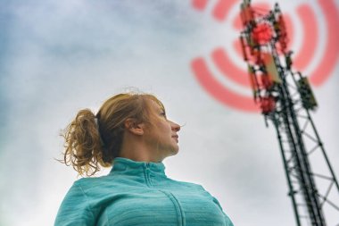 Kadın BTS 'nin yanında duruyor. Hücresel 5G ağ ileticileri kavramından zararlı radyasyon